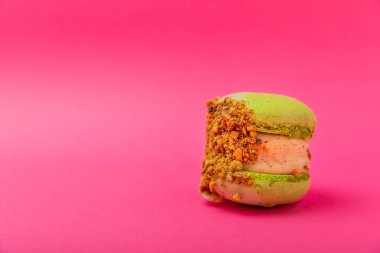 Yumuşak pembe kağıt arka planda lezzetli pembe makaron. Bademli kurabiyeler. Mutfak ve yemek konsepti. Yan görüş. Uzayı kopyala Metin için yer.