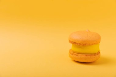 Yumuşak sarı-turuncu kağıt arka planda lezzetli çilekli kurabiyeler. Fransız badem kurabiyesi. Mutfak yemeği konsepti. Uzayı kopyala Yukarıdan görünüm.