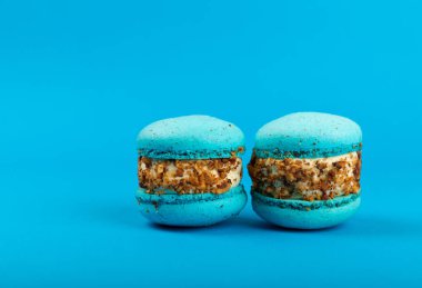 Mavi arka planda Fransız kurabiyeleri. Mavi ve armutlu makarnalar. Fransız tatlısı. Güzel masa. Boşluğu kopyala. Mesaj için yer.