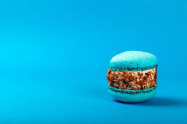 Mavi arka planda Fransız kurabiyeleri. Mavi ve armutlu makarnalar. Fransız tatlısı. Güzel masa. Boşluğu kopyala. Mesaj için yer.