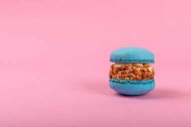 Pembe arka planda Fransız kurabiyeleri. Mavi ve armutlu makarnalar. Fransız tatlısı. Güzel masa. Boşluğu kopyala. Mesaj için yer.