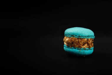 Siyah arka planda Fransız kurabiyeleri. Mavi ve armutlu makarnalar. Fransız tatlısı. Güzel masa. Uzayı kopyala Metin için yer.