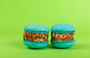 Yeşil arka planda Fransız makarnası. Mavi ve armutlu makarnalar. Fransız tatlısı. Güzel masa. Uzayı kopyala Metin için yer.