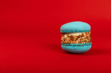 Kırmızı arka planda Fransız makarnası. Mavi ve armutlu makarnalar. Fransız tatlısı. Güzel masa. Uzayı kopyala Metin için yer.