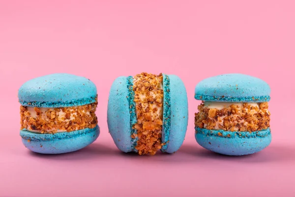 Pembe arka planda Fransız kurabiyeleri. Mavi ve armutlu makarnalar. Fransız tatlısı. Güzel masa. Boşluğu kopyala. Mesaj için yer.