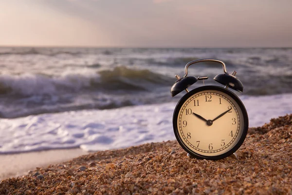 Summer vacation concept. Time to relax. copy space. The concept of an alarm clock on the beach.