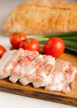 Domuz yağı, yeşil soğan, ev yapımı ekmek ve kiraz domatesli gri taşlı arka plan. Salo olsun. Lezzetli tuzlu domuz yağı ve biber. Kopya için yer var. Metin için boşluk.