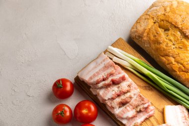 Domuz yağı, yeşil soğan, ev yapımı ekmek ve kiraz domatesli gri taşlı arka plan. Salo olsun. Lezzetli tuzlu domuz yağı ve biber. Kopya için yer var. Metin için boşluk.