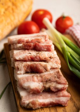 Domuz yağı, yeşil soğan, ev yapımı ekmek ve kiraz domatesli gri taşlı arka plan. Salo olsun. Lezzetli tuzlu domuz yağı ve biber. Kopya için yer var. Metin için boşluk.