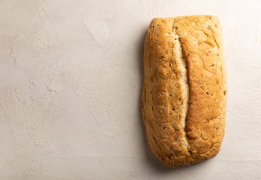 Gri çimento arka planında taze ev yapımı ekmek. Keten tohumlu ekmek, ayçiçeği tohumu ve ekşi ekmek. Organik ev yapımı hamur işleri. Kopyalanacak yer.