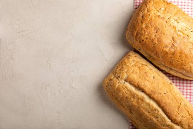 Gri çimento arka planında taze ev yapımı ekmek. Keten tohumlu ekmek, ayçiçeği tohumu ve ekşi ekmek. Organik ev yapımı hamur işleri. Kopyalanacak yer.
