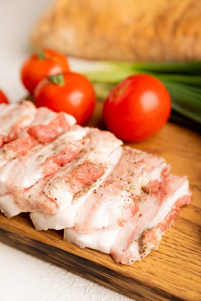 Domuz yağı, yeşil soğan, ev yapımı ekmek ve kiraz domatesli gri taşlı arka plan. Salo olsun. Lezzetli tuzlu domuz yağı ve biber. Kopya için yer var. Metin için boşluk.