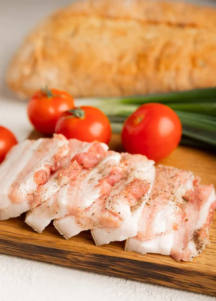 Domuz yağı, yeşil soğan, ev yapımı ekmek ve kiraz domatesli gri taşlı arka plan. Salo olsun. Lezzetli tuzlu domuz yağı ve biber. Kopya için yer var. Metin için boşluk.