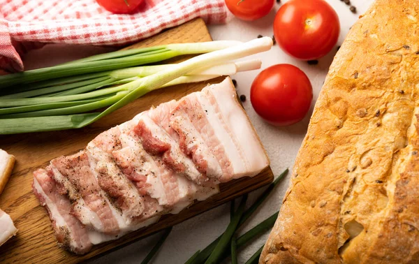Domuz yağı, yeşil soğan, ev yapımı ekmek ve kiraz domatesli gri taşlı arka plan. Salo olsun. Lezzetli tuzlu domuz yağı ve biber. Kopya için yer var. Metin için boşluk.