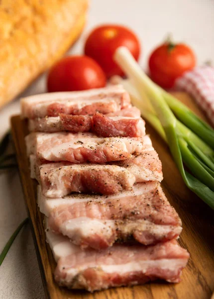 Domuz yağı, yeşil soğan, ev yapımı ekmek ve kiraz domatesli gri taşlı arka plan. Salo olsun. Lezzetli tuzlu domuz yağı ve biber. Kopya için yer var. Metin için boşluk.