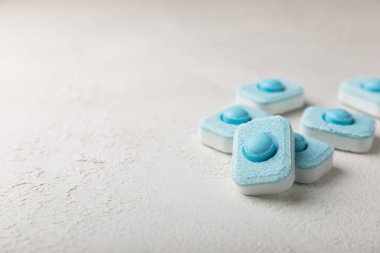 Gri desenli arka planda su yumuşatma hapları. Kireç boyutunu engelleyen çamaşır makineleri ve bulaşık makineleri için kapsüller. Kopyalanacak yer.