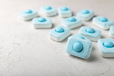 Gri desenli arka planda su yumuşatma hapları. Kireç boyutunu engelleyen çamaşır makineleri ve bulaşık makineleri için kapsüller. Kopyalanacak yer.