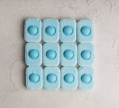 Gri desenli arka planda su yumuşatma hapları. Kireç boyutunu engelleyen çamaşır makineleri ve bulaşık makineleri için kapsüller. Kopyalanacak yer.