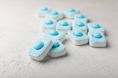 Gri desenli arka planda su yumuşatma hapları. Kireç boyutunu engelleyen çamaşır makineleri ve bulaşık makineleri için kapsüller. Kopyalanacak yer.