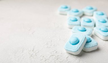 Gri desenli arka planda su yumuşatma hapları. Kireç boyutunu engelleyen çamaşır makineleri ve bulaşık makineleri için kapsüller. Kopyalanacak yer.