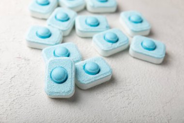 Gri desenli arka planda su yumuşatma hapları. Kireç boyutunu engelleyen çamaşır makineleri ve bulaşık makineleri için kapsüller. Kopyalanacak yer.