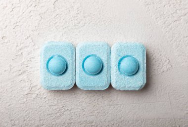 Gri desenli arka planda su yumuşatma hapları. Kireç boyutunu engelleyen çamaşır makineleri ve bulaşık makineleri için kapsüller. Kopyalanacak yer.