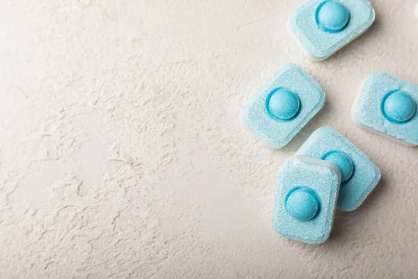 Gri desenli arka planda su yumuşatma hapları. Kireç boyutunu engelleyen çamaşır makineleri ve bulaşık makineleri için kapsüller. Kopyalanacak yer.