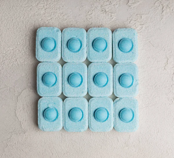 Gri desenli arka planda su yumuşatma hapları. Kireç boyutunu engelleyen çamaşır makineleri ve bulaşık makineleri için kapsüller. Kopyalanacak yer.