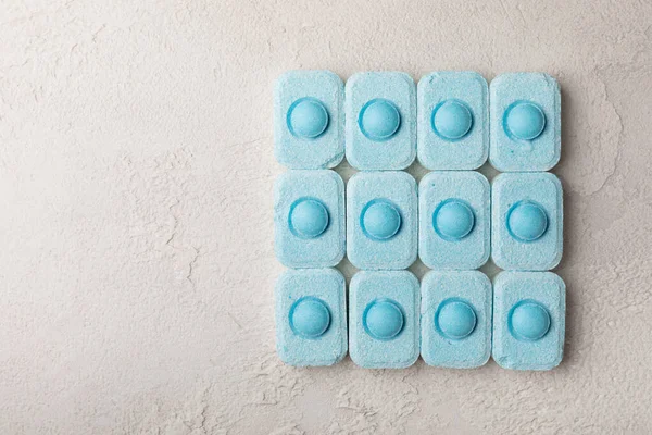 Gri desenli arka planda su yumuşatma hapları. Kireç boyutunu engelleyen çamaşır makineleri ve bulaşık makineleri için kapsüller. Kopyalanacak yer.