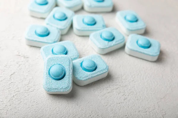 Gri desenli arka planda su yumuşatma hapları. Kireç boyutunu engelleyen çamaşır makineleri ve bulaşık makineleri için kapsüller. Kopyalanacak yer.