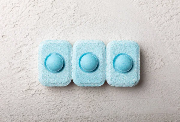 Gri desenli arka planda su yumuşatma hapları. Kireç boyutunu engelleyen çamaşır makineleri ve bulaşık makineleri için kapsüller. Kopyalanacak yer.