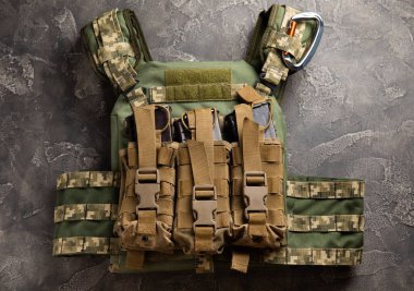 Military body armor on a black marble table. army bulletproof vest. View from above. Military concept.