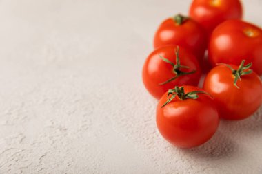 Gri dokuda taze kırmızı domates. Yeşil saplı kiraz domatesleri. Taze sebzeler. Kopyalanacak yer.