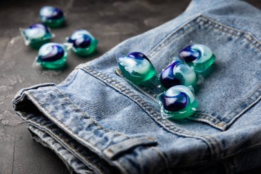 Siyah mermer arka planda mavi kotlu çamaşır kapsülleri. Çamaşır makinesinde çamaşır yıkamak için deterjan. Saflık kavramı. Metin için yer.