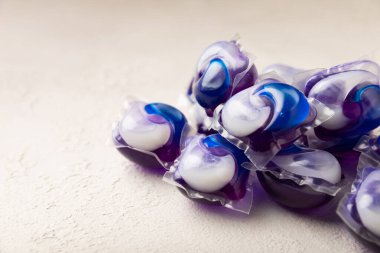 Çamaşır deterjanı yıkamak için kapsüller çamaşır makinesinde çamaşır yıkamak için beyaz mermer arka planda. Saflık kavramı. Metin için yer.