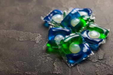 Çamaşır deterjanı yıkamak için kapsüller siyah mermer arka planda çamaşır makinesinde çamaşır yıkamak için. Saflık kavramı. Metin için yer.