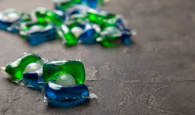 Çamaşır deterjanı yıkamak için kapsüller siyah mermer arka planda çamaşır makinesinde çamaşır yıkamak için. Saflık kavramı. Metin için yer.