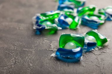 Çamaşır deterjanı yıkamak için kapsüller siyah mermer arka planda çamaşır makinesinde çamaşır yıkamak için. Saflık kavramı. Metin için yer.