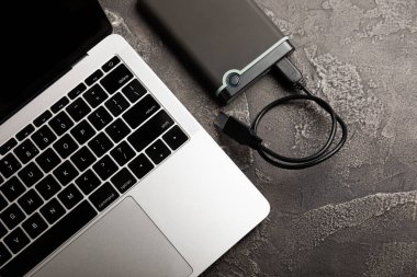 Harici HDD ve siyah çimento arka planda dizüstü bilgisayar. Kopyalanacak yer