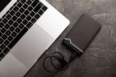 External HDD and laptop on black cement background. Place to copy