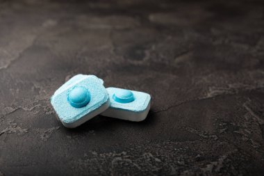 Siyah doku arka planında su yumuşatıcı haplar. Çamaşır makineleri ve bulaşık makineleri için kapsüller, kireçlenme ölçeğini engelliyor. Kopyalanacak yer.