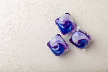 Çamaşır deterjanı yıkamak için kapsüller çamaşır makinesinde çamaşır yıkamak için beyaz mermer arka planda. Saflık kavramı. Metin için yer.