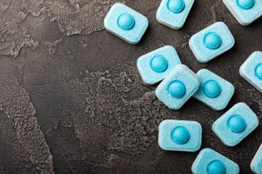 Siyah doku arka planında su yumuşatıcı haplar. Çamaşır makineleri ve bulaşık makineleri için kapsüller, kireçlenme ölçeğini engelliyor. Kopyalanacak yer.