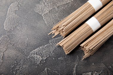 Siyah çimentoyla kaplanmış karabuğday ezmesi. Çiğ erişte. Glütensiz yemek için gerekli malzemeler. Kurutulmuş karabuğday sobalı erişte. Geleneksel Japon yemekleri. Sağlıklı yiyecekler. Kopyalanacak yer.