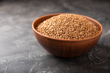 Siyah desenli mermer arka planda bir kasede karabuğday. Çiğ karabuğday. Glüten içermeyen mısır gevreği. Sağlıklı yiyecekler. Kopyalanacak yer.