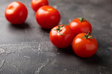 Siyah desenli mermer arka planda taze kırmızı domatesler. Yeşil saplı kiraz domatesleri. Taze sebzeler. Kopyalanacak yer. Organik gıda.