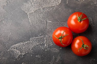 Siyah desenli mermer arka planda taze kırmızı domatesler. Yeşil saplı kiraz domatesleri. Taze sebzeler. Kopyalanacak yer. Organik gıda.