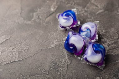 Çamaşır deterjanı yıkamak için kapsüller siyah mermer arka planda çamaşır makinesinde çamaşır yıkamak için. Saflık kavramı. Metin için yer.