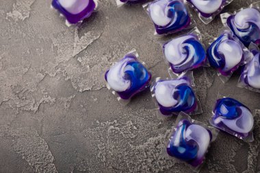 Çamaşır deterjanı yıkamak için kapsüller siyah mermer arka planda çamaşır makinesinde çamaşır yıkamak için. Saflık kavramı. Metin için yer.