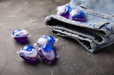 Siyah mermer arka planda mavi kotlu çamaşır kapsülleri. Çamaşır makinesinde çamaşır yıkamak için deterjan. Saflık kavramı. Metin için yer.